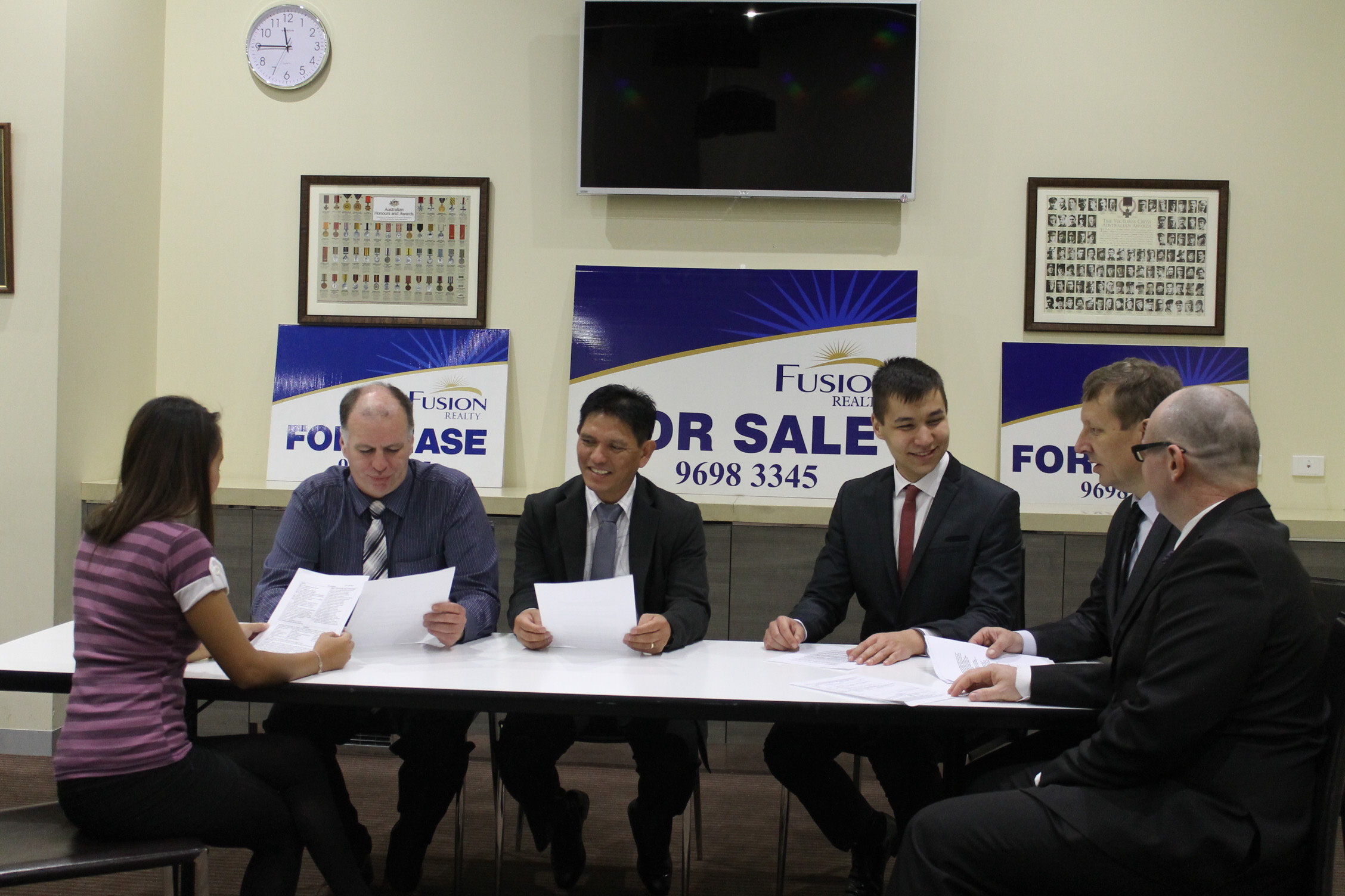 The Fusion Realty team reviewing documents at the office